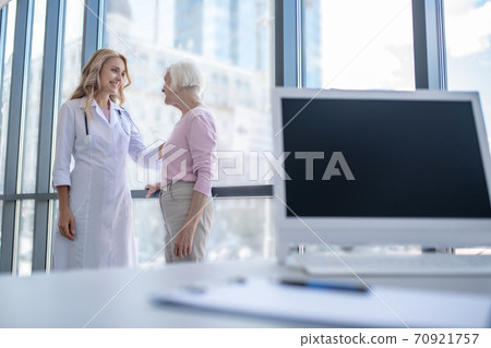 Female doctor putting her hand on patients shoulder Female doctor putting her hand on patients shoulder 70921757