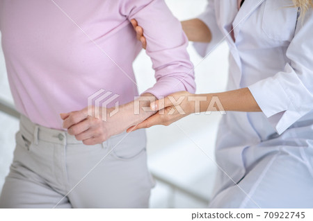 Nurse supporting a woman in a pink shirt Nurse supporting a woman in a pink shirt 70922745