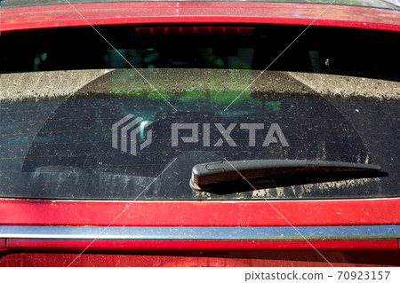 Dirty red car back glass, rear window with wiper  covered with dust after the rain, close-up. 70923157
