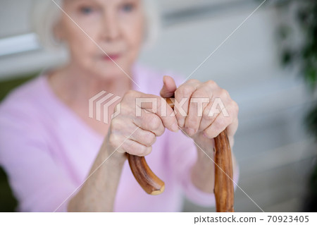 Headshot of a woman in pink shirt and with walking stick Headshot of a woman in pink shirt and with walking stick 70923405