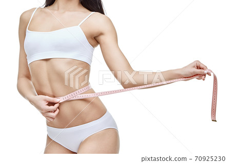 Slim tanned woman's body isolated on white background - waist measurement 70925230