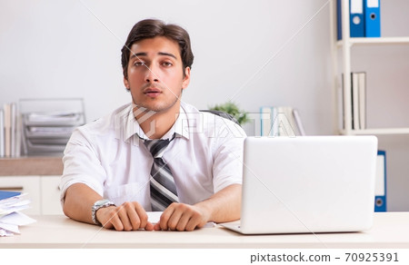 Young handsome businessman working in office Young handsome businessman working in office 70925391