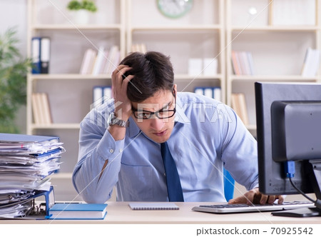 Tired businessman with too much paperwork 70925542