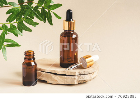 Two brown bottles of cosmetics on a natural beige background. Two brown bottles of cosmetics on a natural beige background. 70925883