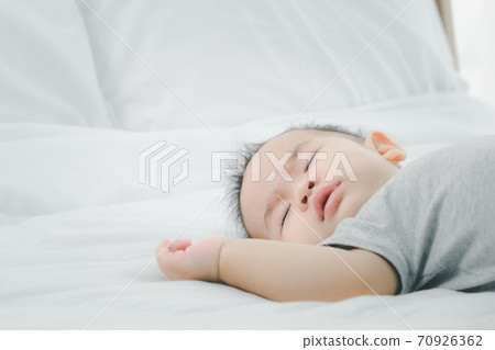 Cute 7 months asian baby girl is sleeping on bed in the morning.Newborn little child sleep have nice dream. 70926362