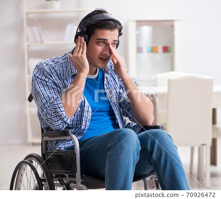 Disabled man listening to music in wheelchair 70926472