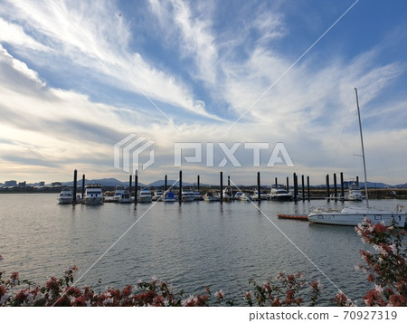Yachts tied under a cloudy blue sky Yachts tied under a cloudy blue sky 70927319