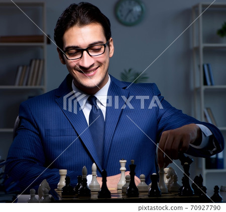 Businessman playing chess in strategy concept 70927790