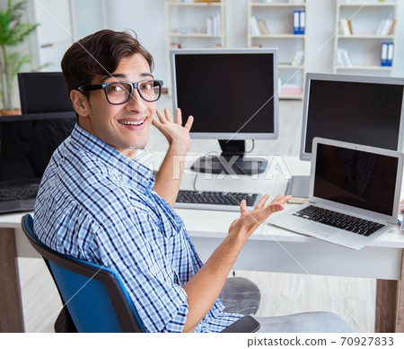 Businessman sitting in front of many screens Businessman sitting in front of many screens 70927833