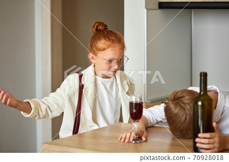 young kids couple at home, boy is drinking alcohol 70928018
