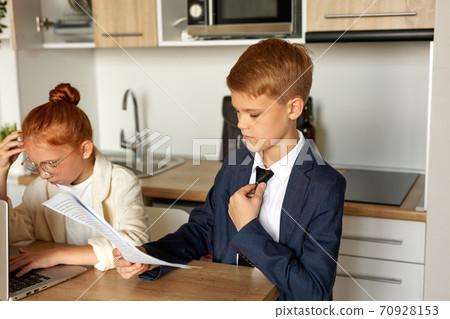 young boy and girl in dormal wear engaged in work at home young boy and girl in dormal wear engaged in work at home 70928153