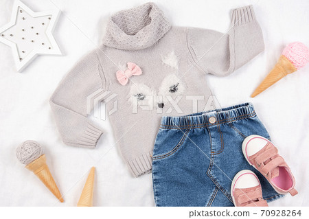 Set of casual child clothes, shoes and accessories on white background. Fashion girl lookbook consept. Knitted sweater, denim skirt, sneakers, ice cream cone. Top view, flat lay Closeup Set of casual child clothes, shoes and accessories on white background. Fashion girl lookbook consept. Knitted sweater, denim skirt, sneakers, ice cream cone. Top view, flat lay Closeup 70928264