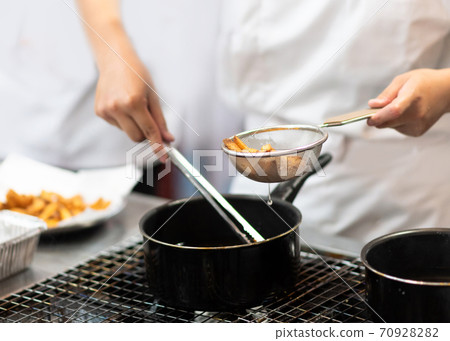 Chef with pans on the stove cooking, Chef preparing food in the kitchen Chef with pans on the stove cooking, Chef preparing food in the kitchen 70928282