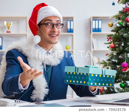 Businessman celebrating christmas holiday in the office Businessman celebrating christmas holiday in the office 70928576
