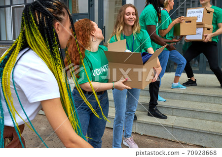 interracial group of volunteers working on humanitarian aid project, outdoors 70928668