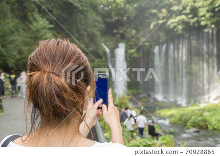 A woman shooting Shiraito Falls in Shizuoka Prefecture 70928865