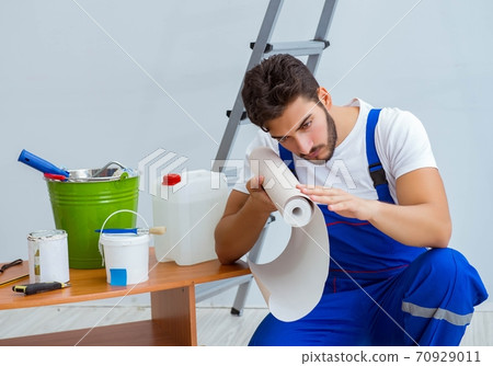 Repairman doing renovation repair in the house with paper wallpa Repairman doing renovation repair in the house with paper wallpa 70929011