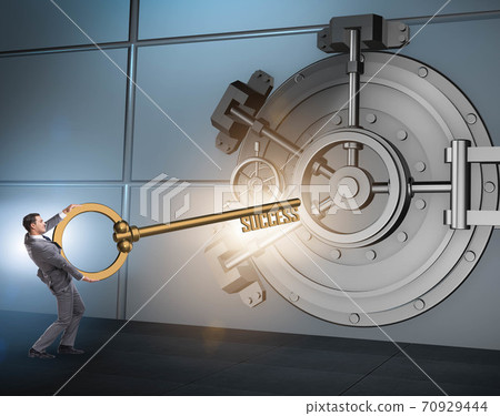 Businessman with key near bank vault door 70929444