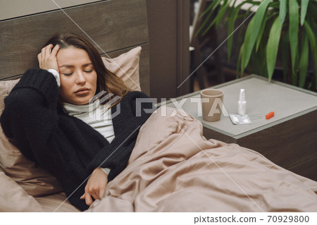Sick woman with headache sitting at home 70929800