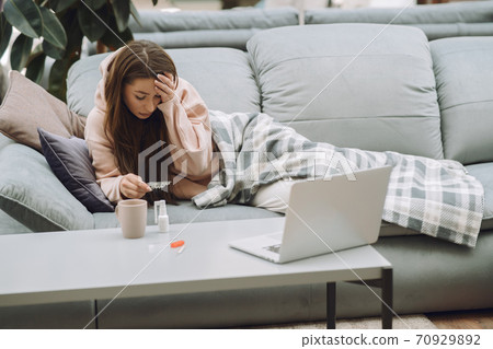 Sick woman with headache sitting at home 70929892