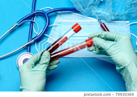 lab technician assistant or doctor holding a blood sample in test tube at laboratory 70930369