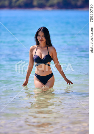 Beautiful asian woman enjoying on a tropical beach Beautiful asian woman enjoying on a tropical beach 70930750