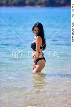 Beautiful asian woman enjoying on a tropical beach Beautiful asian woman enjoying on a tropical beach 70930751