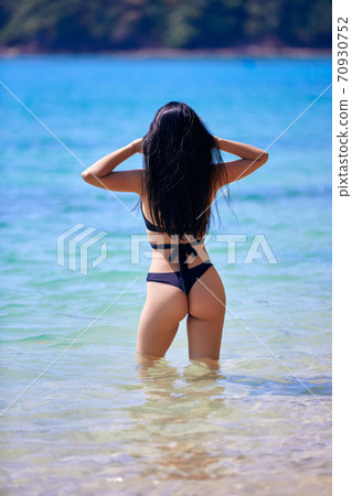 Beautiful asian woman enjoying on a tropical beach Beautiful asian woman enjoying on a tropical beach 70930752