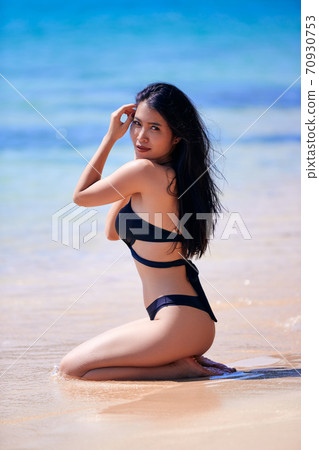 Beautiful asian woman enjoying on a tropical beach Beautiful asian woman enjoying on a tropical beach 70930753