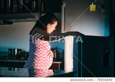 Latin American Pregnant Woman Eating At Night 70930840