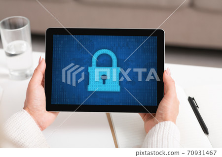 Woman using tablet, padlock icon on the screen Woman using tablet, padlock icon on the screen 70931467