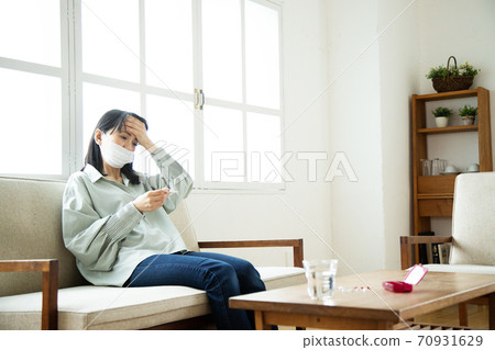 Unwell woman wearing a mask Unwell woman wearing a mask 70931629