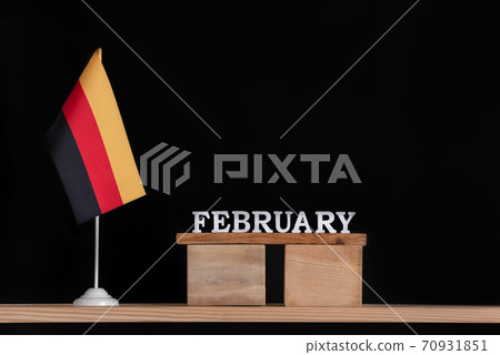 Wooden calendar of February with German flag on black background. Holidays of German in February. Wooden calendar of February with German flag on black background. Holidays of German in February. 70931851