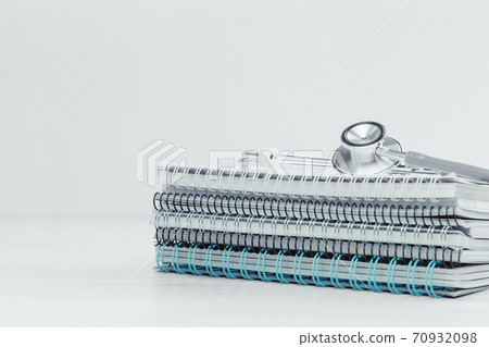 Medical or healthcare concept. stethoscope and pile of spiral notepads Medical or healthcare concept. stethoscope and pile of spiral notepads 70932098