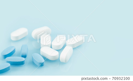 Several white and blue tablets or pills on the table. Medicine and pharmacy Several white and blue tablets or pills on the table. Medicine and pharmacy 70932100