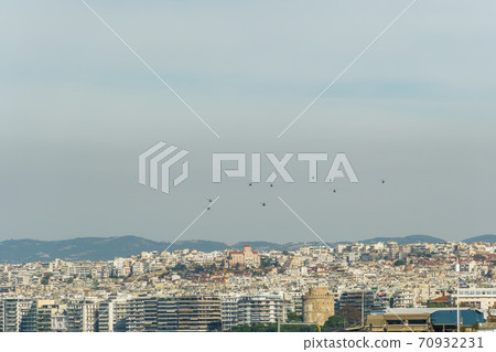 Military helicopters flying above a city. 70932231
