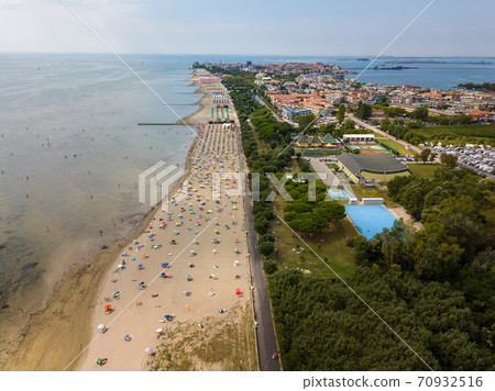 Aerial view of unidentifiable people enjoying summer at the beach of Grado in the province of Gorizia at the Northern Adriatic Sea 70932516