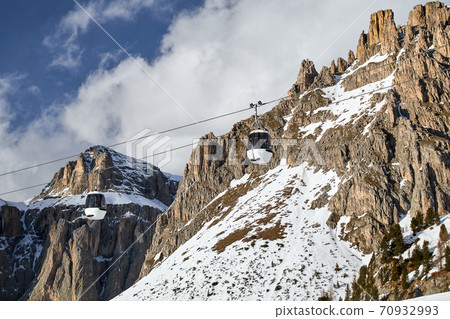 two ski lift cabins in front of the typical rugged, rugged majestic rocks in the Italian Dolomites two ski lift cabins in front of the typical rugged, rugged majestic rocks in the Italian Dolomites 70932993