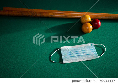 Blue medical face mask for Coronavirus on a green billiard table, protective medical mask for Covid-19 on pool,snooker table 70933447