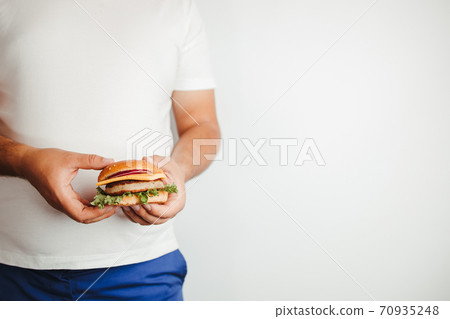 Glutton man eating tasty burger. Fast food Glutton man eating tasty burger. Fast food 70935248