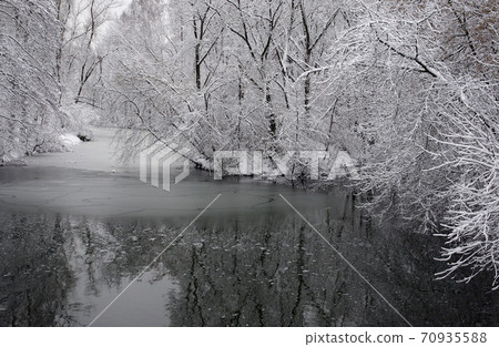 Winter landscape. The snow coating the trees on the river Bank in winter Park. Winter landscape. The snow coating the trees on the river Bank in winter Park. 70935588