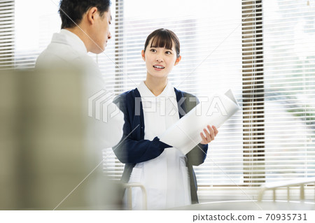 Female nurse consulting with a doctor 70935731
