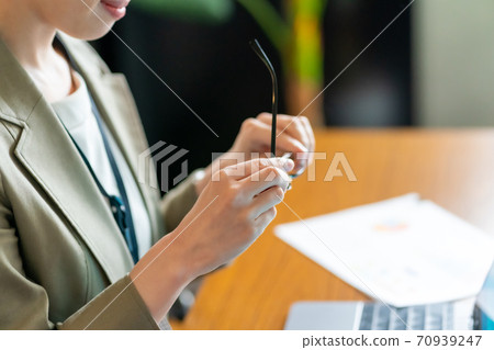 The gesture of a woman who takes off her glasses The gesture of a woman who takes off her glasses 70939247