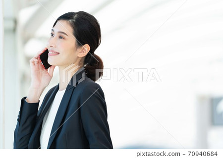 Business woman talking on smartphone [outdoor] 70940684