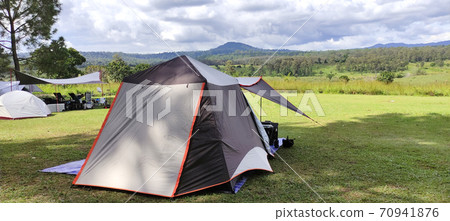 The Campground small Tent and Travel Trailer in the Background. Outdoor Lifestyle Photo . The Campground small Tent and Travel Trailer in the Background. Outdoor Lifestyle Photo . 70941876
