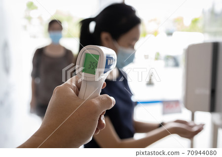 Check body temperature screening using thermometer,prevent people with fever,Coronavirus,cleaning hands with automatic alcohol dispenser,disinfection tunnel,wear face mask at check point for COVID-19 70944080