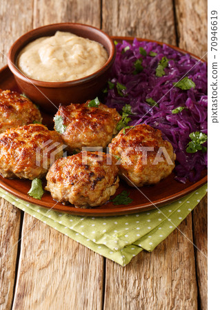 Delicious meatballs served with stewed red cabbage garnish and sauce close-up on the table. vertical Delicious meatballs served with stewed red cabbage garnish and sauce close-up on the table. vertical 70946619