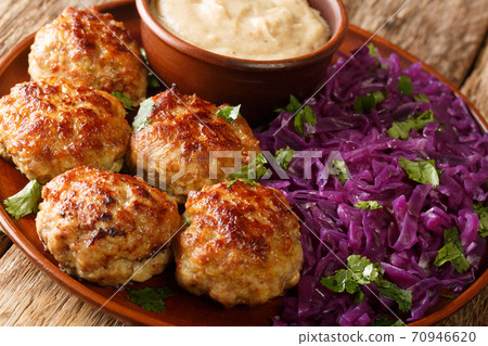 Fried Danish meatballs with hot stewed red cabbage and sauce close-up in a plate. horizontal Fried Danish meatballs with hot stewed red cabbage and sauce close-up in a plate. horizontal 70946620