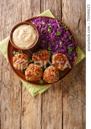 Delicious meatballs served with stewed red cabbage garnish and sauce close-up on the table. vertical top view Delicious meatballs served with stewed red cabbage garnish and sauce close-up on the table. vertical top view 70946625