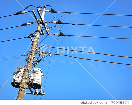 High-voltage line and two transformers seen in the clear sky 70946894